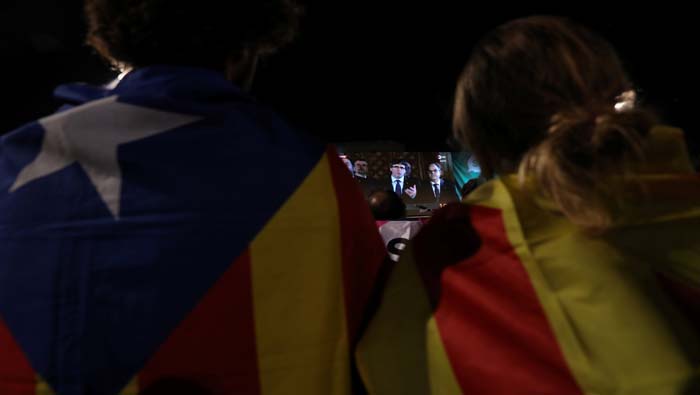 Dos personas con esteladas (bandera soberanista catalana), el domingo, mientras Puigdemont declaraba tras el referendo.