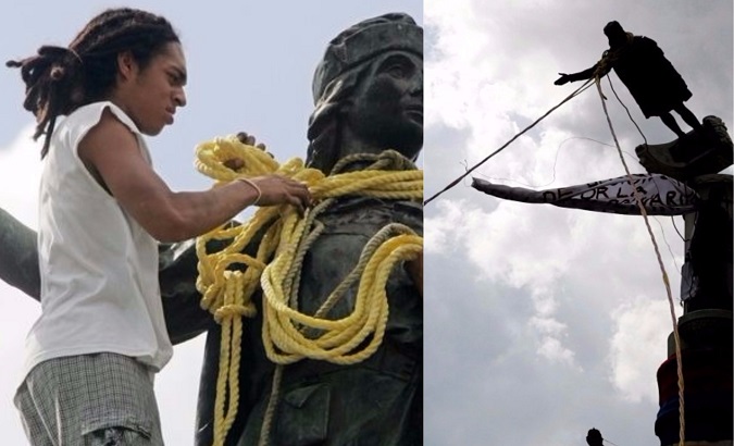 Venezuelan demonstrators use ropes to take down a Christopher Columbus statue in Caracas, Venezuela, October 12, 2004.