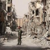 A fighter from Syrian Democratic Forces (SDF) stands next to debris of damaged buildings in Raqqa, Syria September 25, 2017.