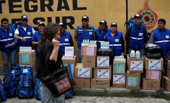 Members of a health brigade look at Bolivia's Health Minister Ariana Campero.