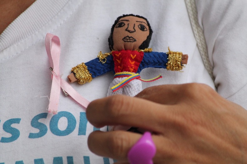 A demonstrator shows her pin of Venezuelan liberator, Simon Bolivar.