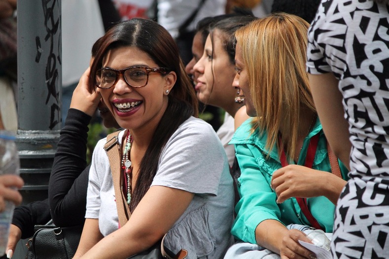 A woman smiles while marching against the right-wing economic war to destabilize Venezuela.