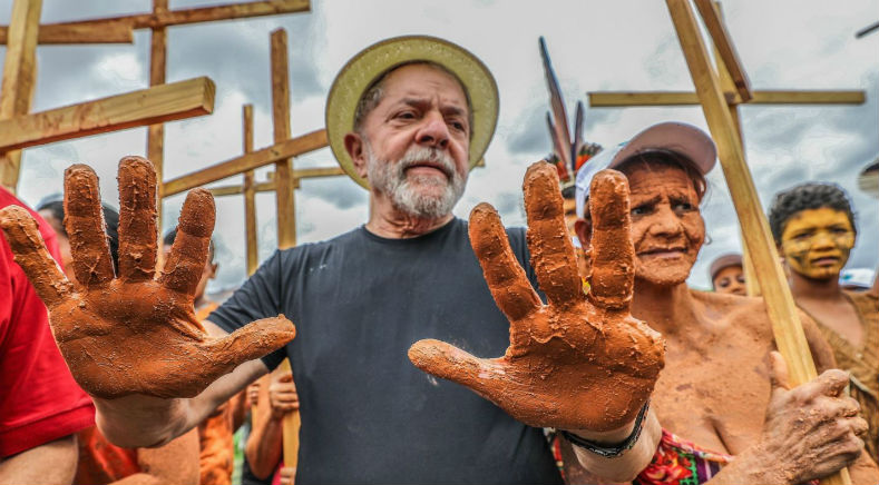 In Governador Valadares, Lula spoke with residents about environmental crimes in the aftermath of the November 2015 dam burst. High-level executives from Brazilian mining companies Samarco and Vale have been charged with those crimes. In 1964, Lula's pinky finger was severed while he operated heavy machinery in a metallurgical factory in the state of Sao Paulo. He was 18 years old.