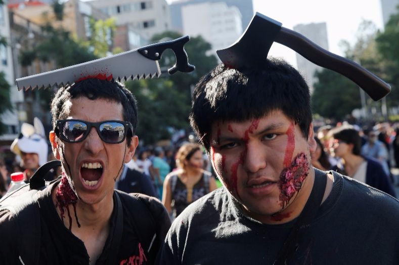 Two participants with costume tools attached to their heads at the Zombie Walk in Mexico City.