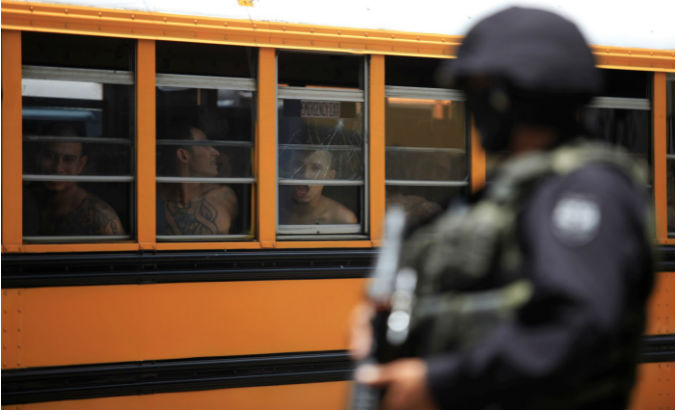 A Salvadoran policeman guards buses as 1,282 members of the Barrio 18 gang are transferred from a jail in Cojutepeque.
