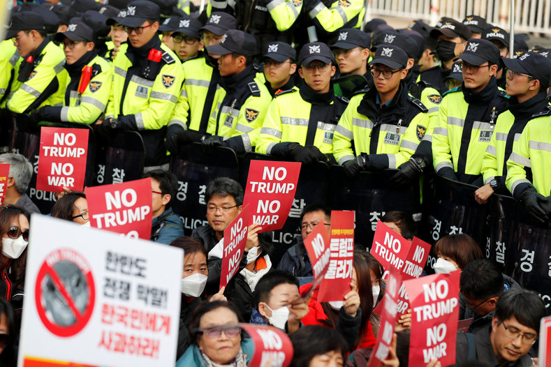 Protesters against U.S. President Donald Trump wait for Trump's motorcade to pass by as police stand guard in central Seoul, South Korea, Nov. 7, 2017. 