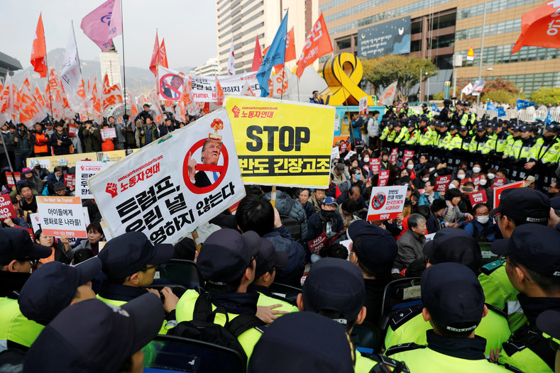 Police surround protesters against U.S. President Donald Trump who are waiting for Trump's motorcade to pass by in central Seoul, South Korea, Nov. 7, 2017.