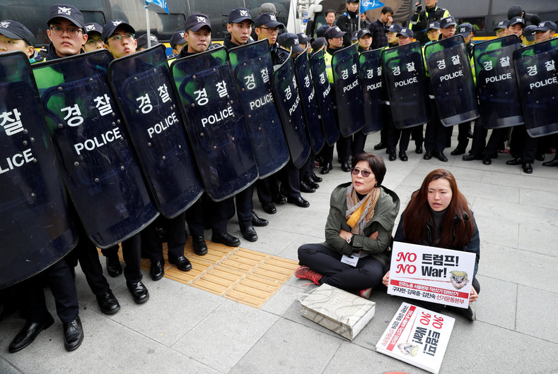 Police surround protesters against U.S. President Donald Trump waiting for Trump's motorcade to pass by in central Seoul, South Korea, Nov. 7, 2017. 