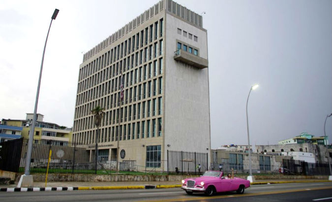 A car with tourists drives past the U.S. Embassy in Havana, Cuba.