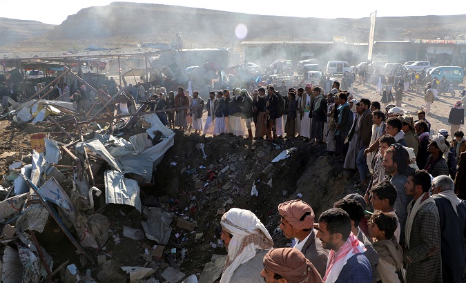 People gather at the site of an air strike in the northwestern city of Saada, Yemen.