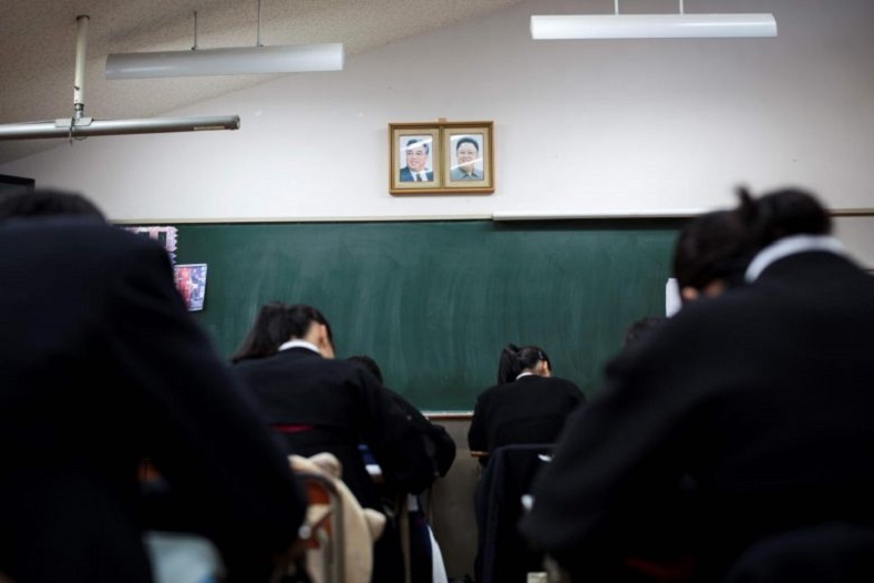 Students take an exam beneath portraits of late North Korean leaders Kim Il-Sung and Kim Jong-Il in a classroom at Tokyo Korean high school.