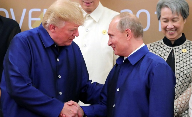 President Trump and Russian President Vladimir Putin shake hands as they take part in a family photo at the APEC summit.