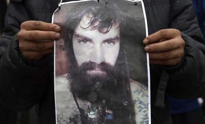 A person holds a poster of Santiago Maldonado during a march to demand justice.