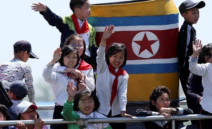 Children from the DPRK wave during a tour on the Yalu River in Sinuiju, near the Chinese border city of Dandong.