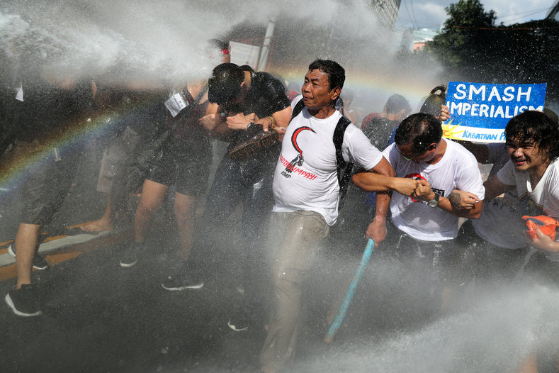Protesters are hit by a water cannon as they try to march towards the U.S. embassy during a rally against U.S. President Donald Trump's visit, in Manila, Philippines November 12, 2017.