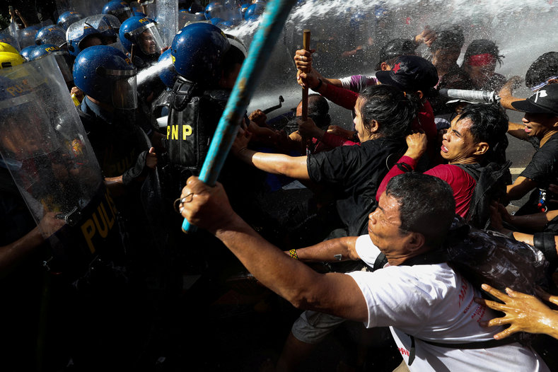 Protesters fight back against tactical police officers as they try to march towards the U.S. embassy during a rally against U.S. President Donald Trump's visit, in Manila, Philippines, November 12, 2017.