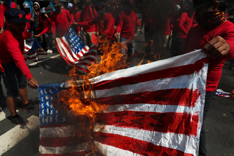 Protesters burn homemade U.S. flags to denounce the visit of U.S. President Donald Trump, who will attend the 31st Association of Southeast Asian Nations (ASEAN) leaders summit, during a protest along a main street in metro Manila, Philippines, November 12, 2017.