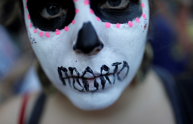 A woman demonstrates with a face painting representing a dead woman after an illegal abortion, in Rio de Janeiro.