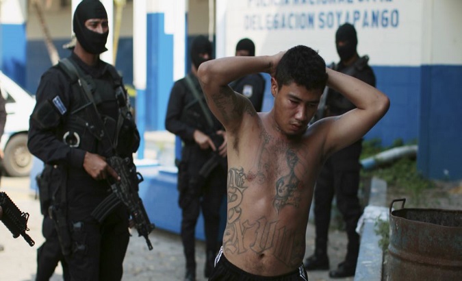 A suspected gang member is seen being arrested in Soyapango, El Salvador, March 31, 2016.