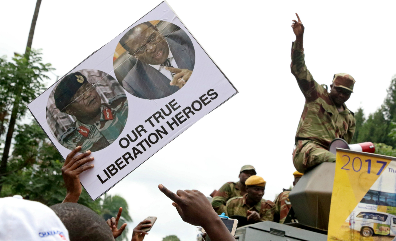 Protesters calling for Zimbabwean President Robert Mugabe to step down take to the streets waving placards with pictures of ousted Vice President Emmerson Mnangagwa and General Constantino Chiwenga in Harare, Zimbabwe, November 18, 2017.