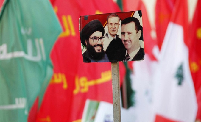 Supporters wave pictures of Hezbollah leader Nasrallah, Syria's late President Hafez al-Assad, and current Syrian President Bashar al-Assad.