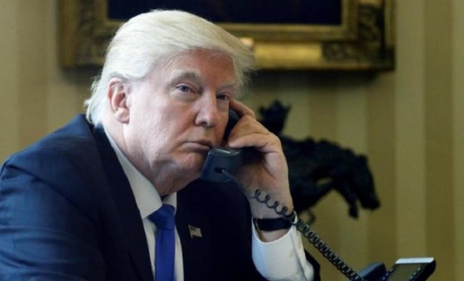 President Donald Trump pictured on the phone in the Oval Office.