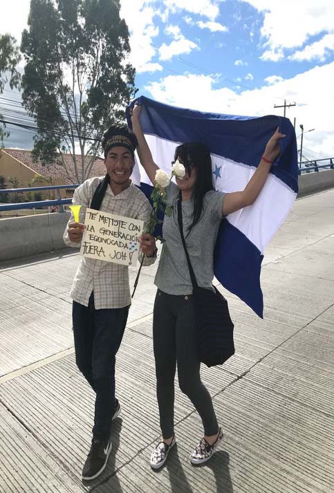 Unos jóvenes caminaron con la bandera de Honduras, rosas blancas y un cartel que decía: "Te metiste con la juventud equivocada, fuera JOH".  