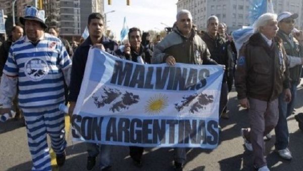 Argentines march with banner thats reads, 