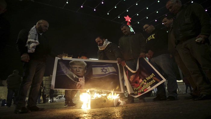 Varios palestinos quemaron un afiche con la imagen del presidente estadounidense Donald Trump y la bandera israelí durante una protesta en Belén, Cisjordania.