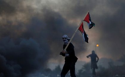 A demonstrator holds a Palestinian flag during clashes with Israeli troops after Trump's decision to recognize Jerusalem as Israel's capital.
