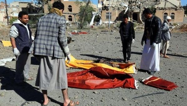 Yemenis collect the corpses of people killed in Saudi airstrike in Sana'a