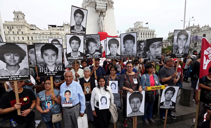 People holding pictures of victims of the conflict in the 1980s and 1990s march after Peruvian President Kuczynski pardoned former President Alberto Fujimori.