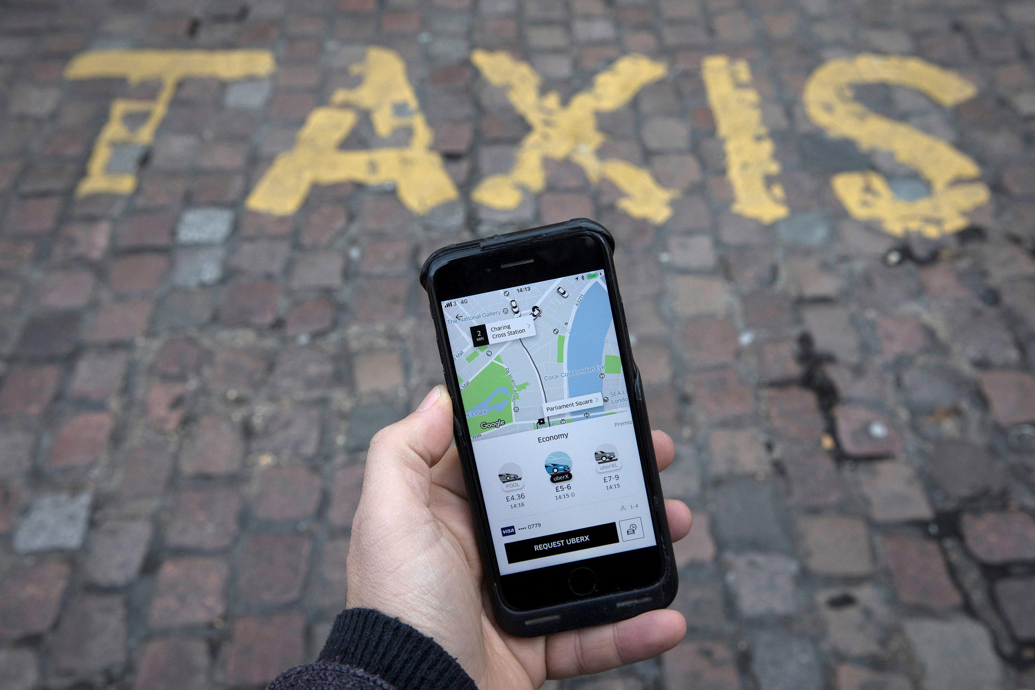 A photo illustration shows the Uber app on a mobile telephone, as it is held up for a posed photograph, in London, Britain Nov. 10, 2017.