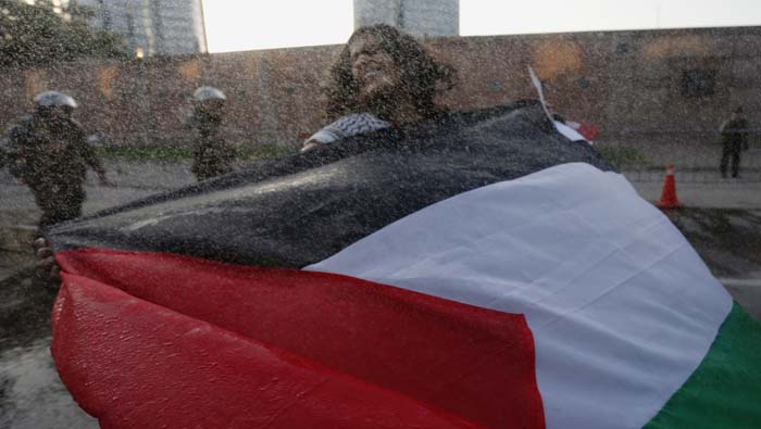 Mujer frente a la embajada de EE.UU. en Chile protestó el 11 de diciembre.