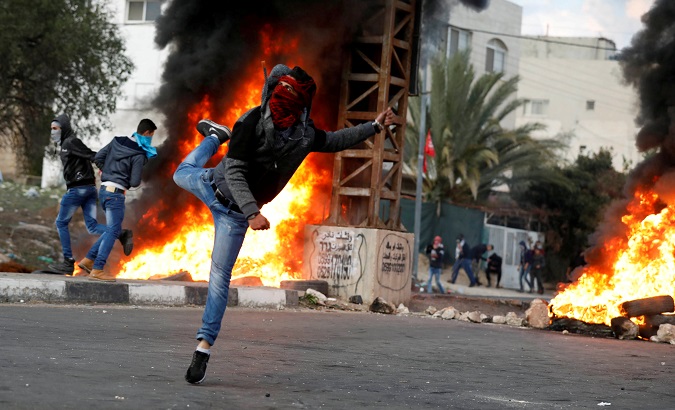 Palestinian demonstrator hurls stones toward Israeli troops during clashes at a protest near the West Bank city of Nablus.