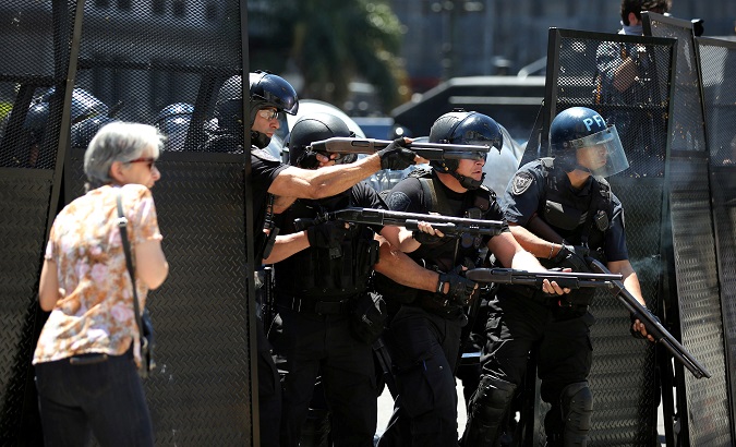 A woman reacts as Argentine policemen fire rubber bullets during clashes outside the Congress on Dec. 14.
