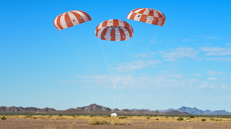 Tres paracaídas principales de naranja y blanco durante una prueba el 13 de septiembre.