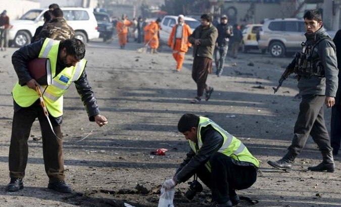 Afghan security forces investigate at the site of a suicide bomb attack.