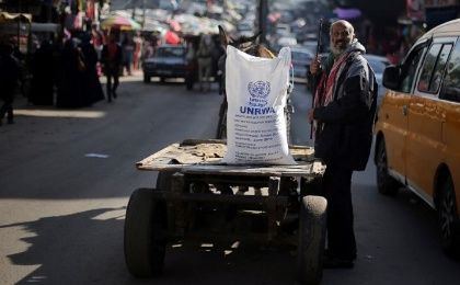 A Palestinian man stands next to a cart carrying a flour sack distributed by UNRWA in Khan Younis refugee camp in the southern Gaza Strip Jan. 3, 2018.