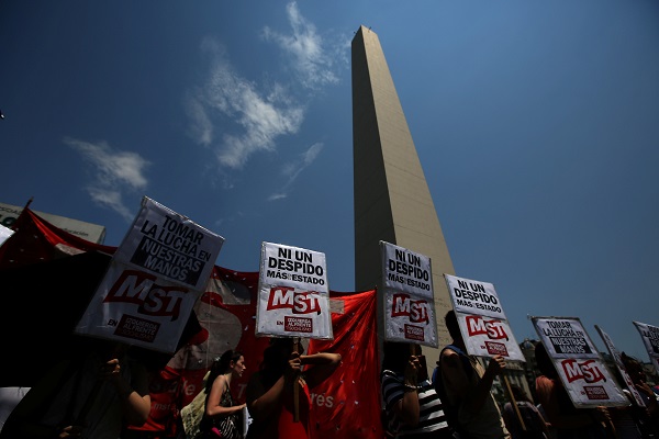 Demonstrators holds banners that read in Spanish, 'No more state layoffs', during a protest against layoffs in Argentina.