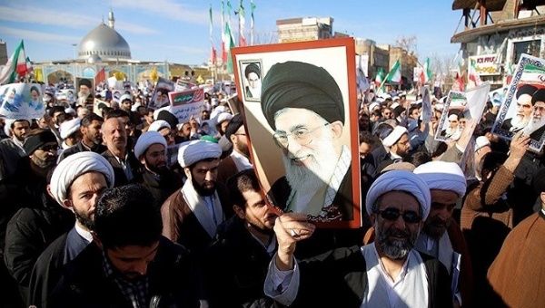 Pro-government counter-protesters hoist pictures of Supreme Leader Ayatollah Ali Khamenei.