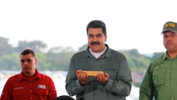 Venezuela's President Nicolas Maduro (Center) holds a gold bar during a meeting with representatives of the mining sector in Puerto Ordaz, Venezuela.