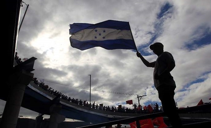 A support of Honduras' Opposition Alliance waves a flag during a street rally in San Pedro Sula.