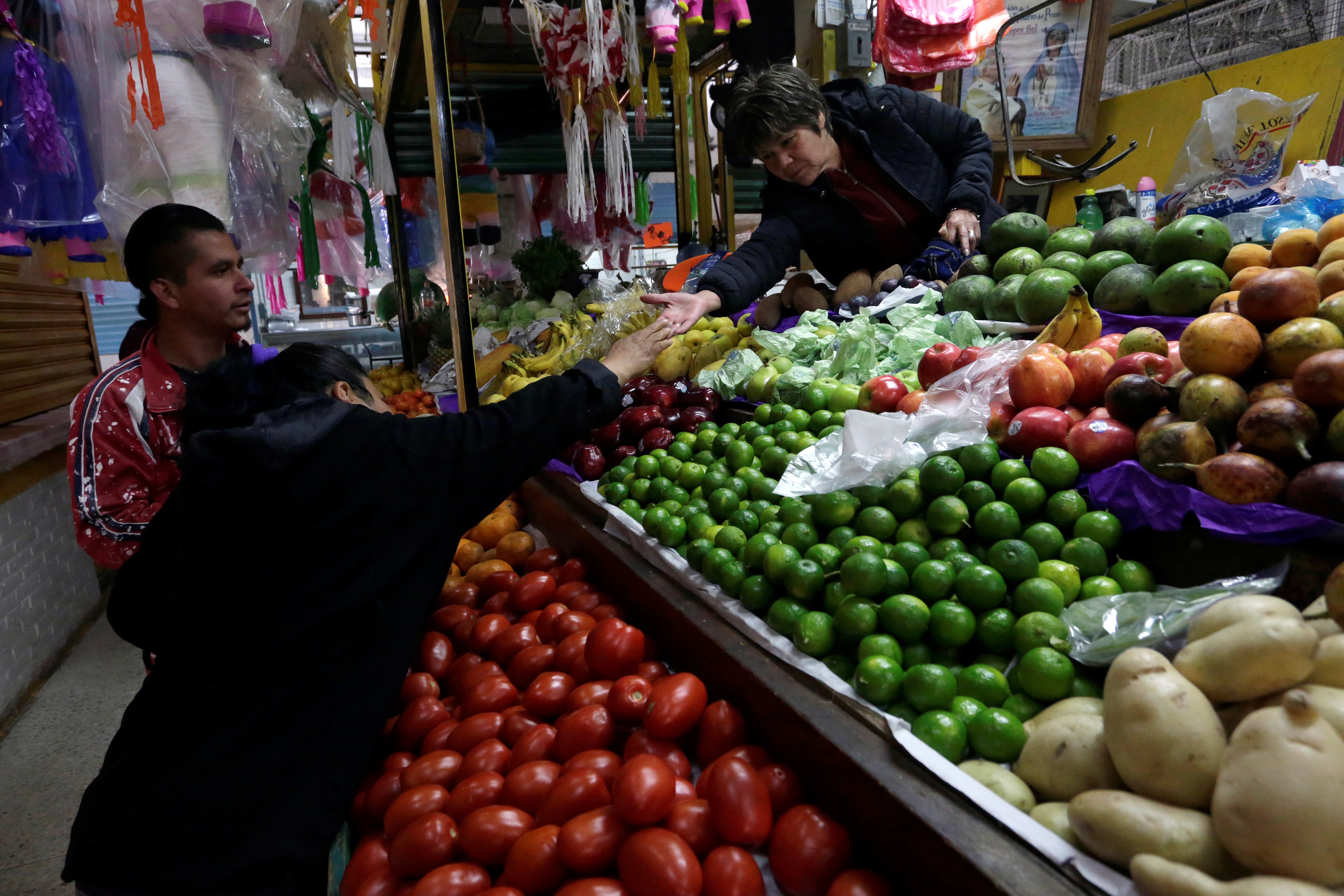 A woman buys vegetables at a market stall in Mexico City, January 2018.