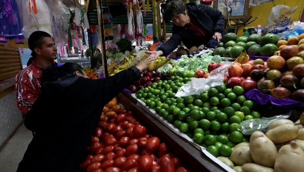 A woman buys vegetables at a market stall in Mexico City, January 2018.