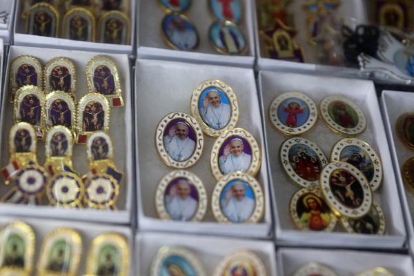 Pin-back buttons bearing images of the pontiff are seen on display in Lima.