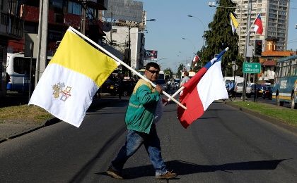 Chilean and Vatican flags are carried by a man ahead of the papal visit in Temuco, Chile.