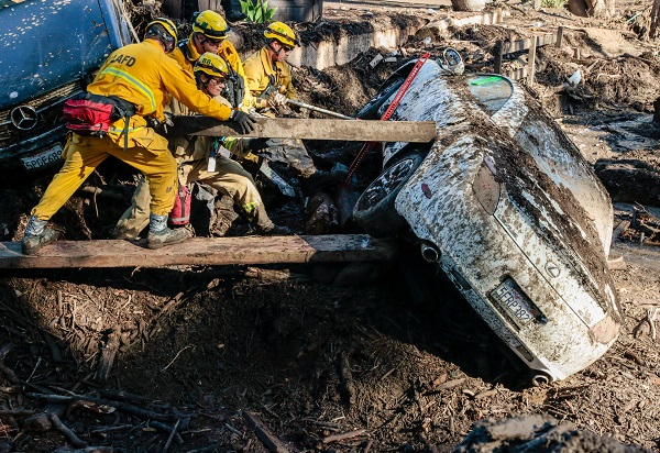 Excavators carrying rescuers in their buckets plowed through mud-coated roads in search of the missing after some areas were buried in as much as 4.6 meters of mud, emergency officials said.