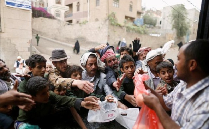 People gather to collect food rations at a food distribution center in Sanaa, Yemen on March 21, 2017.
