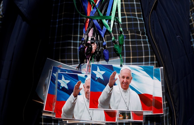 A man exhibits on his chest photos of Pope Francis to sell outside St. Jose Cathedral ahead of the papal visit in Temuco, Chile, January 14, 2018.